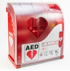A red and white AED (Automated External Defibrillator) wall cabinet with a heart and lightning bolt symbol, emergency instructions, and a transparent front panel showing the device inside.