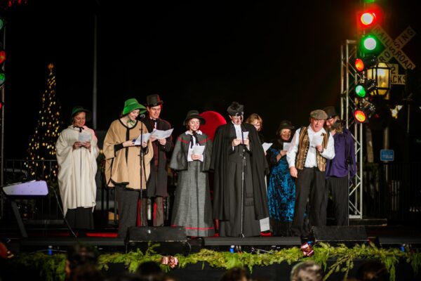 Victorian-costumed performers sing on stage during the Dickens on Centre festival on Amelia Island