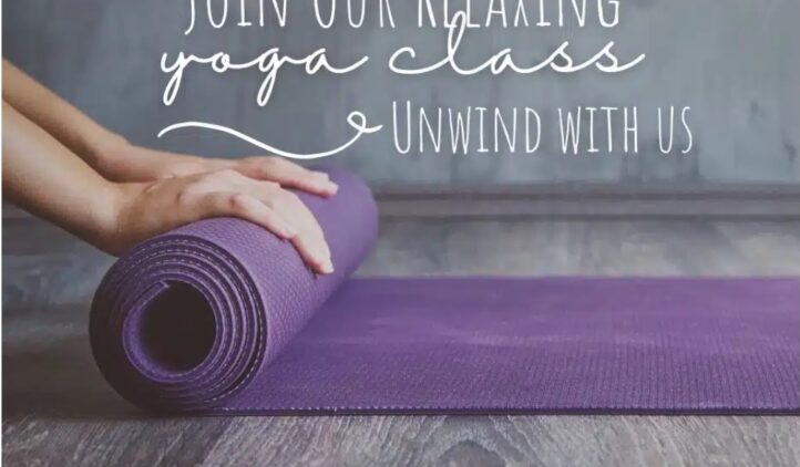 A person’s hands rolling out a purple yoga mat on a wooden floor. Text reads: Join Our Relaxing Yoga Class. Unwind with us. The setting looks calm and inviting.
