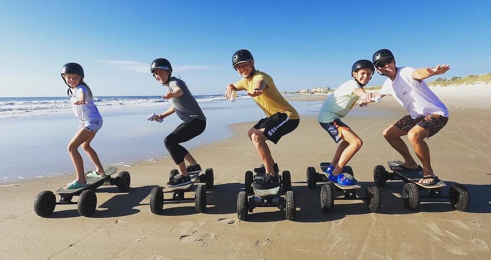 family skateboarding on beach